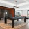 a room with a pool table and chairs