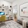 A well-organized home office featuring a sleek white desk, modern shelving with decor accents, a comfortable green chair, and a view into the open-concept living area.
