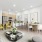 A stylish apartment living space with a cozy sofa, chic green accent chairs, a sleek kitchen with light wood cabinetry, and a marble dining table.